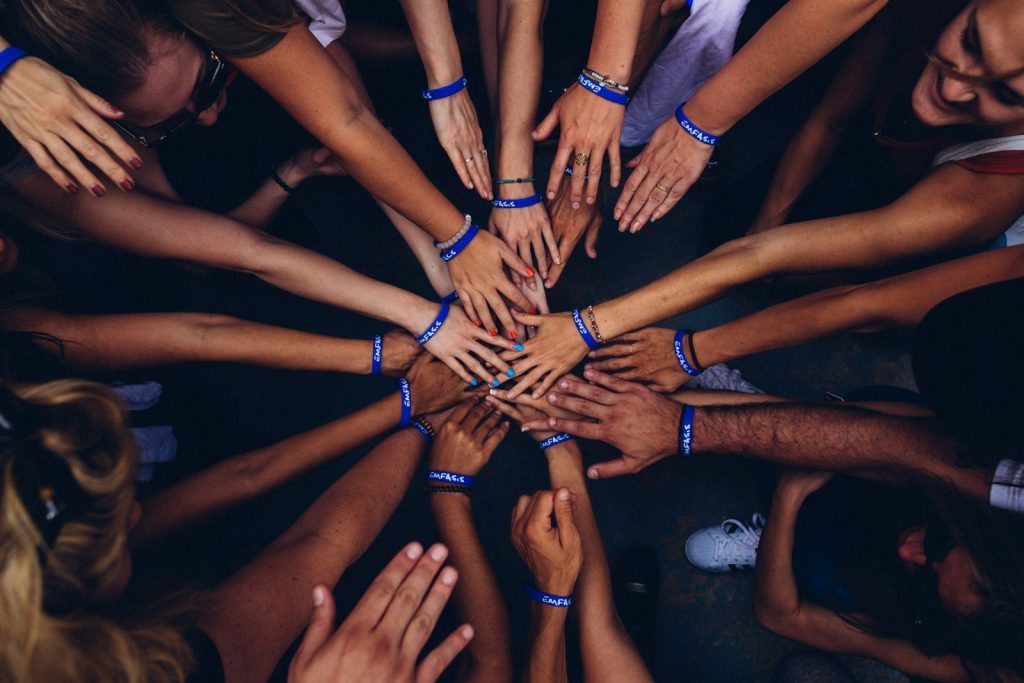 Many hands joined together in a circle